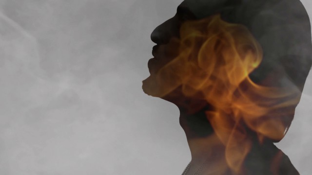 Rising Sun videoclip screenshot, singer on fire